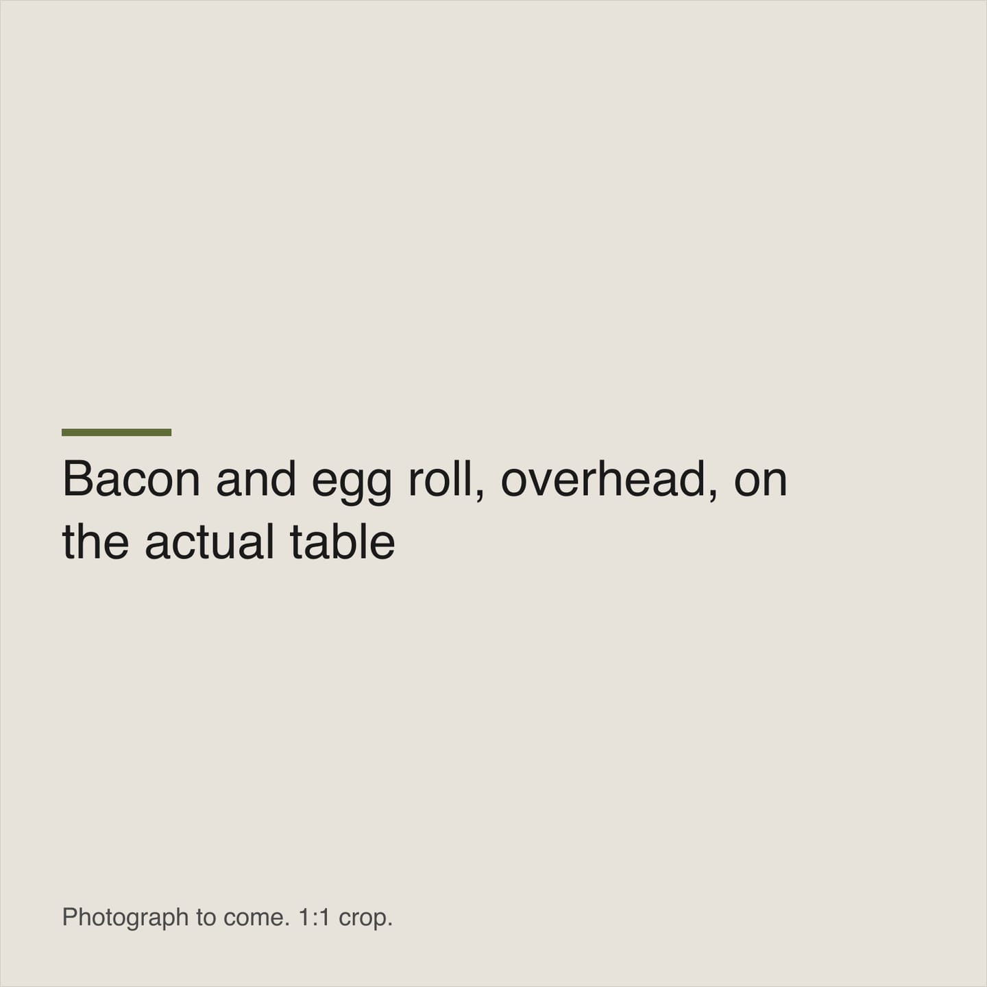A bacon and egg roll on a plate on one of the cafe tables.